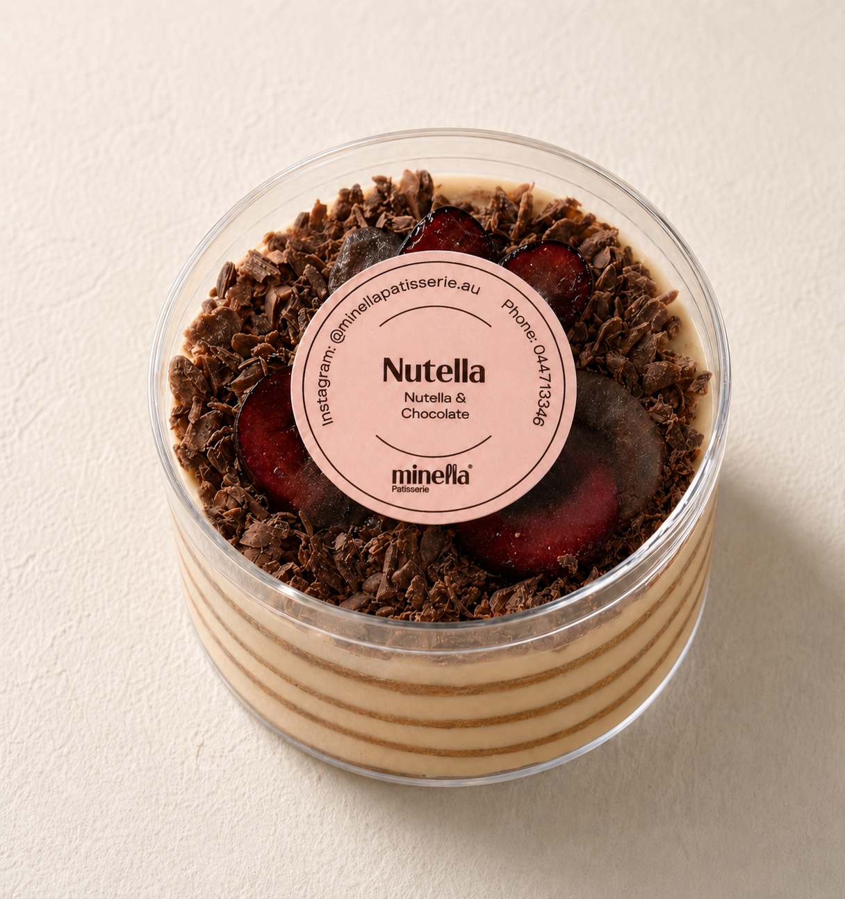 Minella Patisserie Nutella dessert layered with creamy Nutella filling, chocolate shavings, and fresh plum slices.